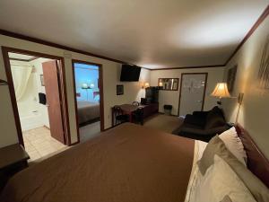 a hotel room with a bed and a living room at Highland Court Motel in Fairmont