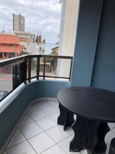 a black table on the balcony of a building at apartamento bombinhas in Bombinhas
