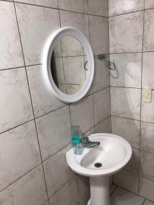 a bathroom with a sink and a mirror at apartamento bombinhas in Bombinhas