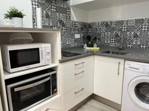 a kitchen with a microwave and a washing machine at Apartamento La Mezquita-Catedral in Córdoba