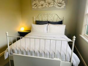 een wit bed met witte lakens en kussens bij Bush Retreat Farm Stay 2 BR in Gelliondale