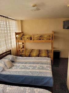 a bedroom with two bunk beds and a tv at Hostal Haziel in Salinas