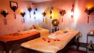 two beds in a room with flowers and candles at New Bahia in Marrakesh