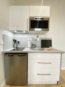 a kitchen with a sink and a microwave at ModernAppart Marmande Centre in Marmande