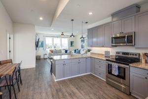 a kitchen with gray cabinets and a dining room at Beach Town Home - Walk to Beaches Downtown Activities and so much more in Half Moon Bay