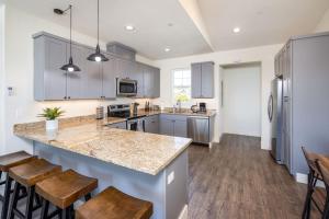 a kitchen with a large island with wooden stools at Beach Town Home - Walk to Beaches Downtown Activities and so much more in Half Moon Bay