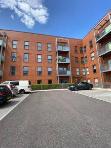 a parking lot in front of a large brick building at 3 Bedrooms double or single beds, 2 PARKING SPACES! WIFI & Smart TV's, Balcony in Portsmouth