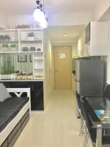 a kitchen with a refrigerator and a table in it at Sea Residences MoA Manila in Manila