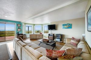 a living room with a couch and a tv at Seabird Lodge in Rockaway Beach