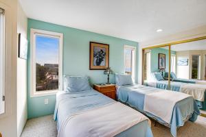 a room with three beds and two windows at Seabird Lodge in Rockaway Beach