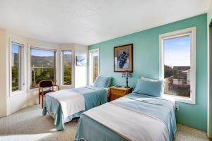two beds in a room with two windows at Seabird Lodge in Rockaway Beach +34 photos