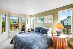 a bedroom with a bed and windows at Seabird Lodge in Rockaway Beach