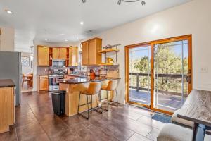 a kitchen with wooden cabinets and a large window at Whispering Pines in Flagstaff