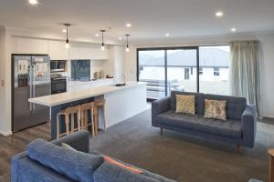 a living room with two couches and a kitchen at Loudon Lodge - Lake Tekapo in Lake Tekapo