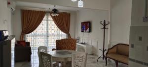 sala de estar con mesa, sillas y ventana en Nenda’s Home, en Port Dickson