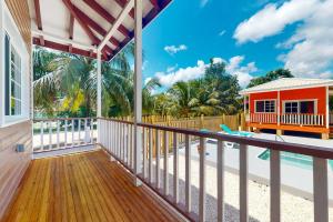 a home with a balcony with a pool and a house at Came at Hummingbird Estate Gold Standard Certified in Dangriga