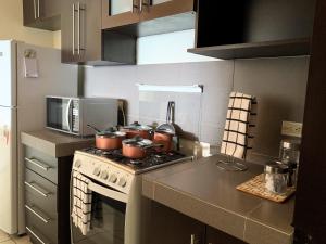 una cocina con fogones con ollas y sartenes. en Luxury Modrn Apartment, w/amazing view, 3BR,Escalon,Exclus,Secur en San Salvador