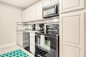een keuken met zwarte apparaten en witte kasten bij Eagle Haven - H1 in Myrtle Beach