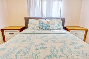 een bed met een blauwe deken en twee nachtkastjes bij Eagle Haven - H1 in Myrtle Beach