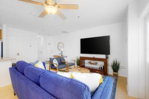 Sofá azul en la sala de estar con ventilador de techo en Star Beach Side Condominiums #105 en South Padre Island