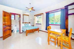 a bedroom with a bed and a desk and a table at Kiara at Hummingbird Estate Gold Standard Certified in Dangriga