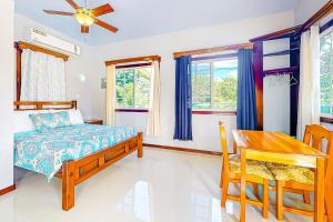 Schlafzimmer mit einem Bett, einem Tisch und Stühlen in der Unterkunft Kiara at Hummingbird Estate Gold Standard Certified in Dangriga
