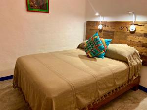a bedroom with a bed with two pillows on it at Aurinko Bungalows in Sayulita