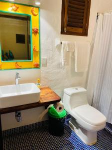 a bathroom with a toilet a sink and a mirror at Aurinko Bungalows in Sayulita