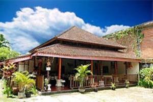 a house with a porch and a roof at Agung Trisna Bungalows in Ubud