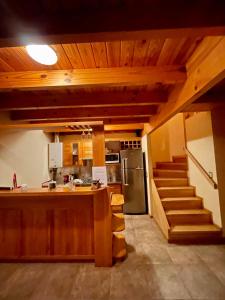 eine Küche mit einer Theke und eine Küche mit einer Treppe in der Unterkunft Apart Quillen 1 in San Martín de los Andes