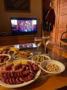 a table topped with plates of food and glasses of wine at Apart Quillen 1 in San Martín de los Andes