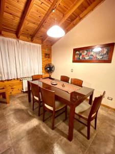 a dining room with a wooden table and chairs at Apart Quillen 1 in San Martín de los Andes