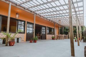 an outdoor patio with a pergola in a building at Alecrim Pousada in Praia do Rosa