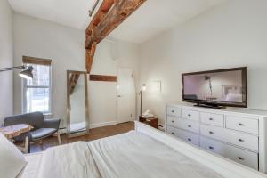 a bedroom with a tv and a dresser with a bed at The Mill #210 in Ludlow