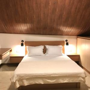 1 dormitorio con 1 cama blanca grande y 2 lámparas en Vimala Hills Villa 4 Bedroom with Mountain View, en Bogor