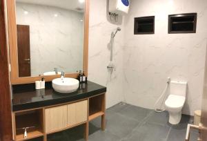 ein Bad mit einem Waschbecken und einem WC in der Unterkunft Vimala Hills Villa 4 Bedroom with Mountain View in Bogor