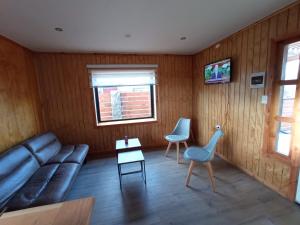 a living room with a couch and two chairs at Cabañas Trabun-Leufu in La Unión +1 photo