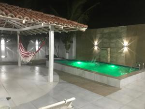 a swimming pool at night with a fountain at Casa de praia Luiz Correia paraíso azul in Luis Correia