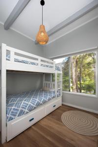 ein Schlafzimmer mit einem weißen Etagenbett und einem Fenster in der Unterkunft High View Haven, Surf Beach in Surf Beach
