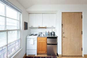 een keuken met witte kasten, een wastafel en een fornuis bij Flexhome Economy Studio Apt F1 - READ INFO in Milwaukee