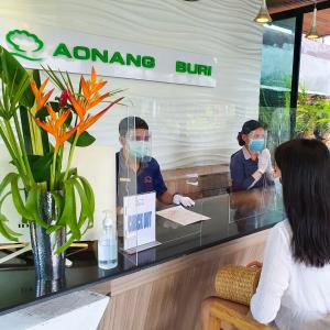 two people wearing face masks at a restaurant at Aonang Buri Resort- SHA Extra Plus in Ao Nang Beach