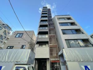 a tallartment building with a truck parked in front of it at Mr Kintaro Hotel Asakusa South in Tokyo