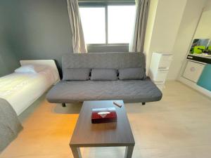 a living room with a couch and a coffee table at Mr Kintaro Hotel Asakusa South in Tokyo