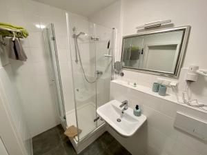 bagno bianco con lavandino e doccia di Bärliner Hotel a Erfurt