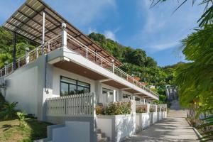 Casa blanca con balcón con plantas en Memory Karon Resort, en Karon Beach