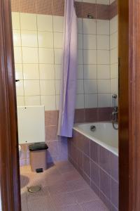 ein Badezimmer mit einem lila Duschvorhang, einer Badewanne und einem WC in der Unterkunft Esperides in Kos-Stadt