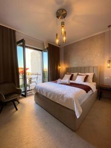 a bedroom with a large bed and a balcony at CoolKush Boutique in Constanţa