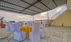 a table and chairs on a patio with a view of the ocean at Hotel Vishvam Residency Udaipur in Udaipur +66 photos