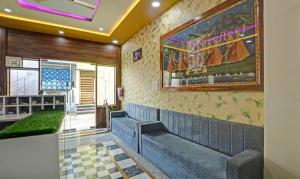 a waiting room with a couch and a painting on the wall at Hotel Vishvam Residency Udaipur in Udaipur