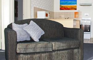a couch with two pillows on it in a kitchen at Aquarius Resort in Merimbula